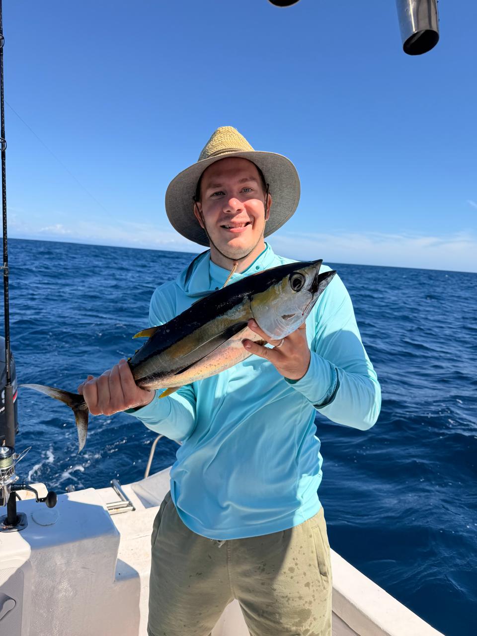 Captain Dario holding a yellowfin tuna offshore